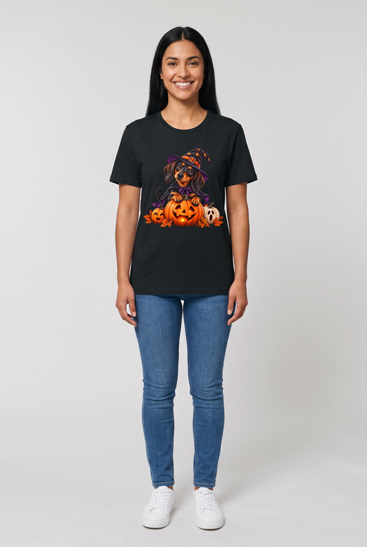 Woman wearing a black dachshund witch Halloween t-shirt with a wiener dog in a witch hat and cape on a glowing jack-o-lantern, front view