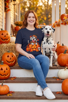 Frau im Dalmatiner Hexen Halloween T-Shirt in Navy mit Dalmatiner in Hexenhut und Kürbis-Umhang auf einer Kürbislaterne, auf einer Herbstveranda mit einem Dalmatiner und Kürbissen