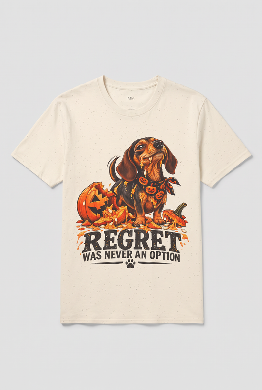 Flat lay of a natural funny dachshund Halloween t-shirt with a wiener dog next to a smashed jack-o-lantern and the text Regret Was Never An Option