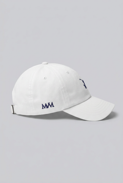 Color: White. Golf cap, angled side view with navy Swing dachshund and MVM monogram