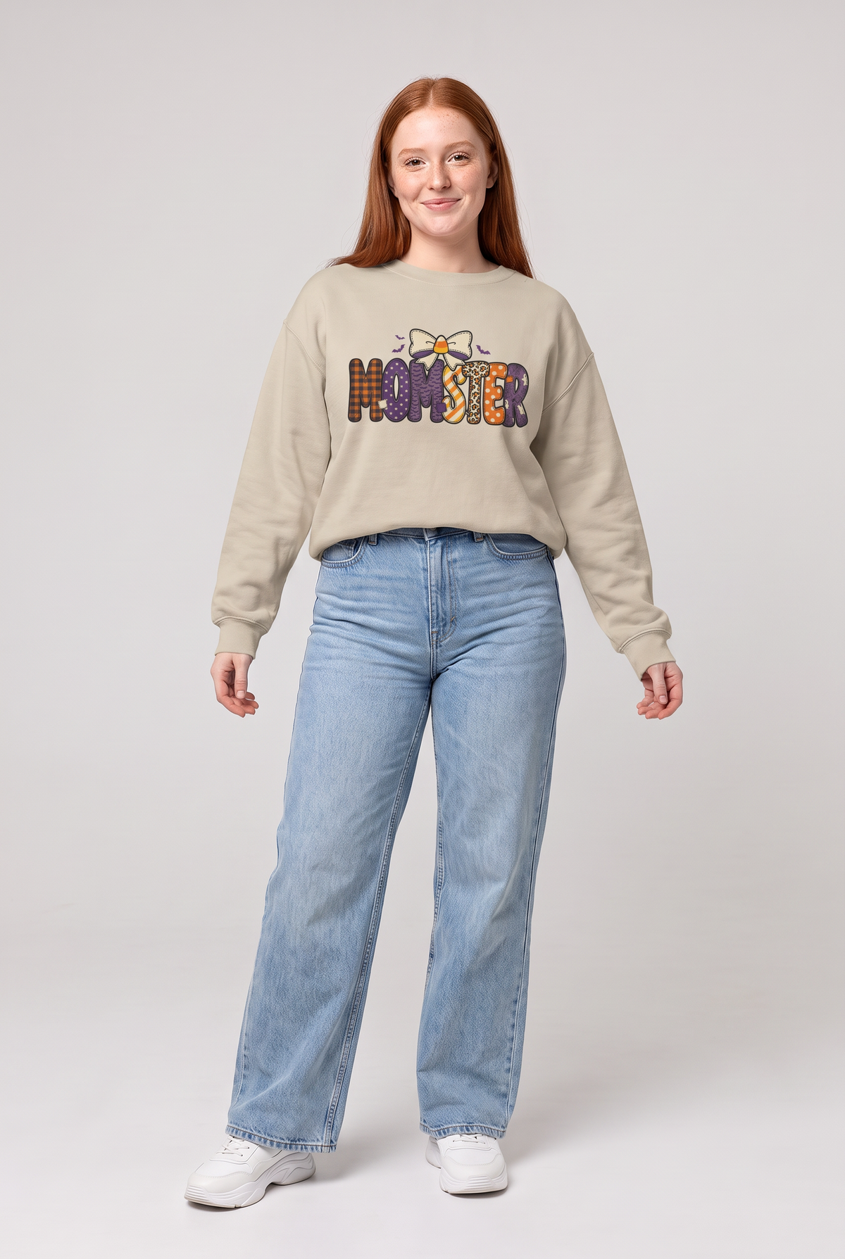 Woman wearing the Momster Halloween sweatshirt in sand, front view. Color: Sand