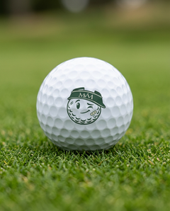 Mulligan golf ball in forest green and cream print, close-up on green grass