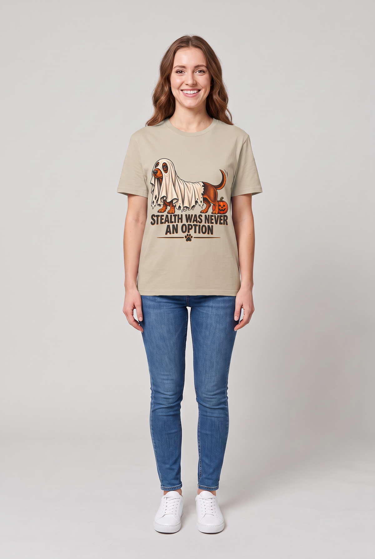 Frau trägt ein Dackel Halloween T-Shirt in Sand mit Dackel unter einem zu kurzen Gespensterlaken und dem Spruch Stealth Was Never An Option, Vorderansicht