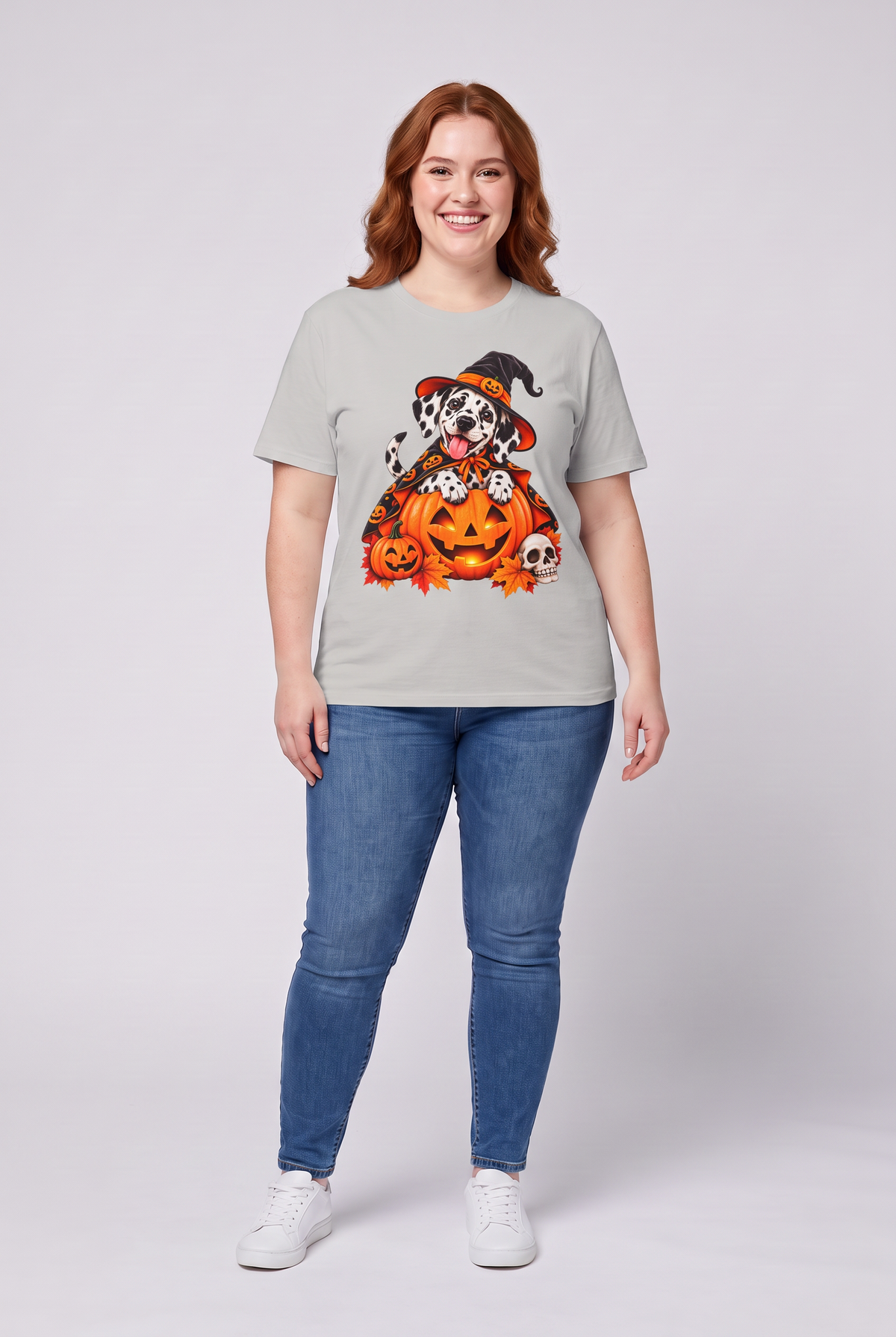 Frau trägt ein Dalmatiner Hexen Halloween T-Shirt in Ice Grey mit Dalmatiner in Hexenhut und Kürbis-Umhang auf einer Kürbislaterne, Vorderansicht