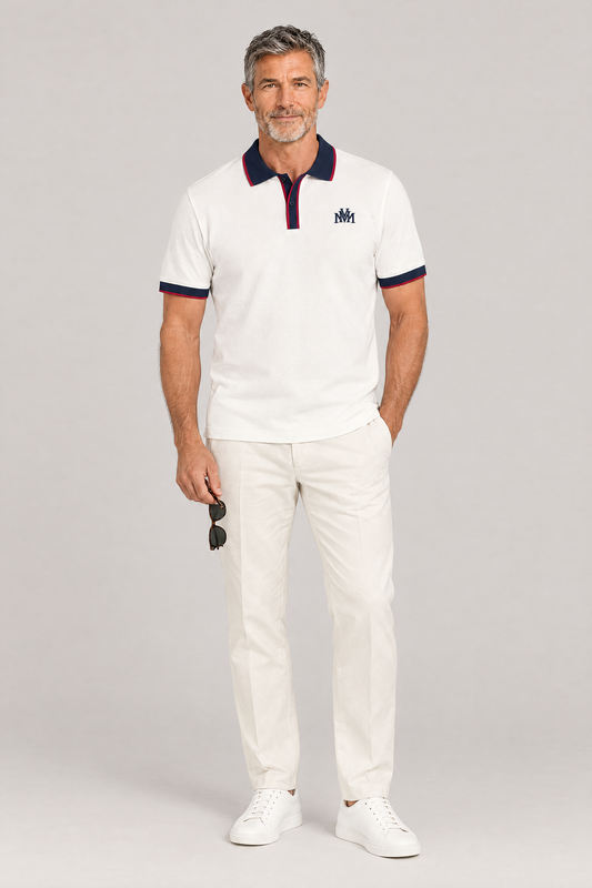 Man wearing the white Club Crest color block polo with navy trim, holding sunglasses, full body. Color: White with Navy Blue