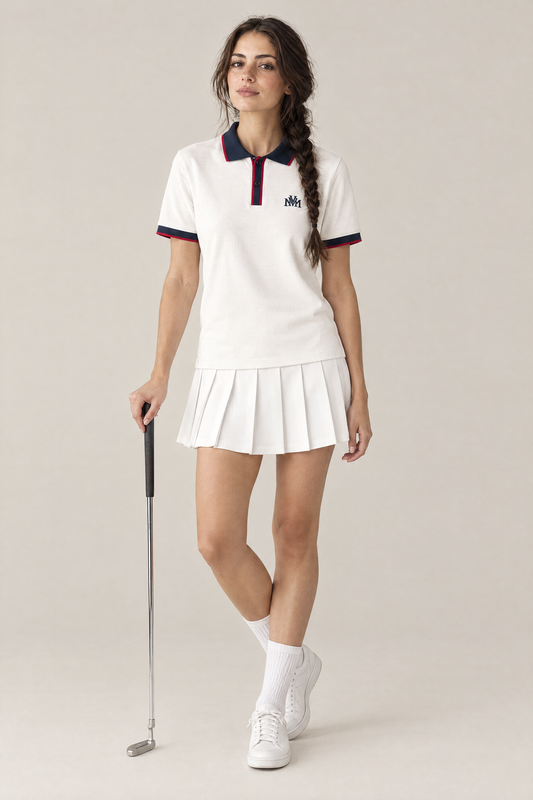 Woman wearing the Club Crest color block polo in white with navy trim and a pleated golf skirt, holding a putter. Color: White with Navy Blue