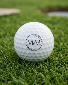 Pure Ball golf ball in navy and burgundy print, close-up on green grass