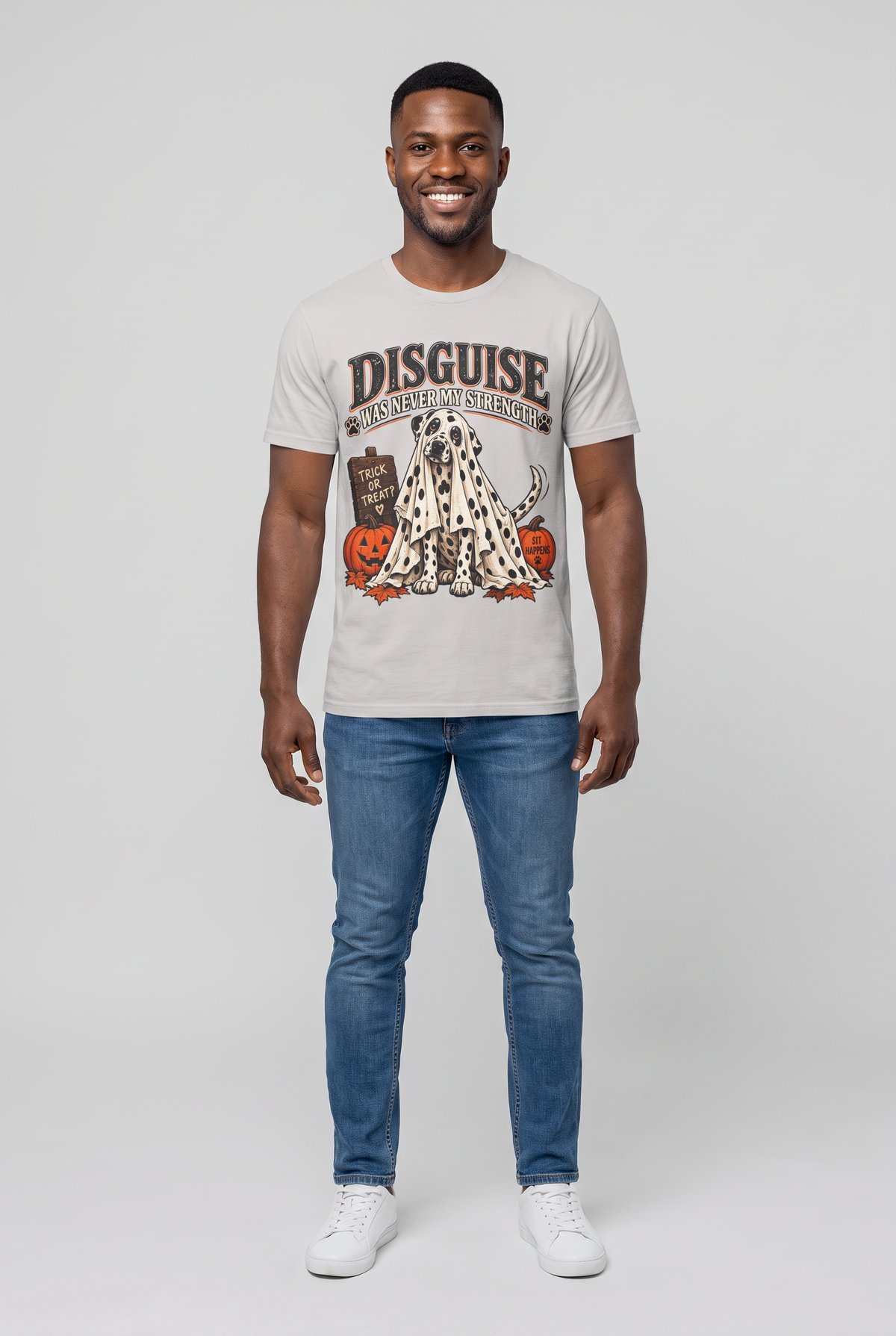 Mann trägt ein Dalmatiner Halloween T-Shirt in Ice Grey mit Dalmatiner unter einem gepunkteten Gespensterlaken und dem Spruch Disguise Was Never My Strength, Vorderansicht