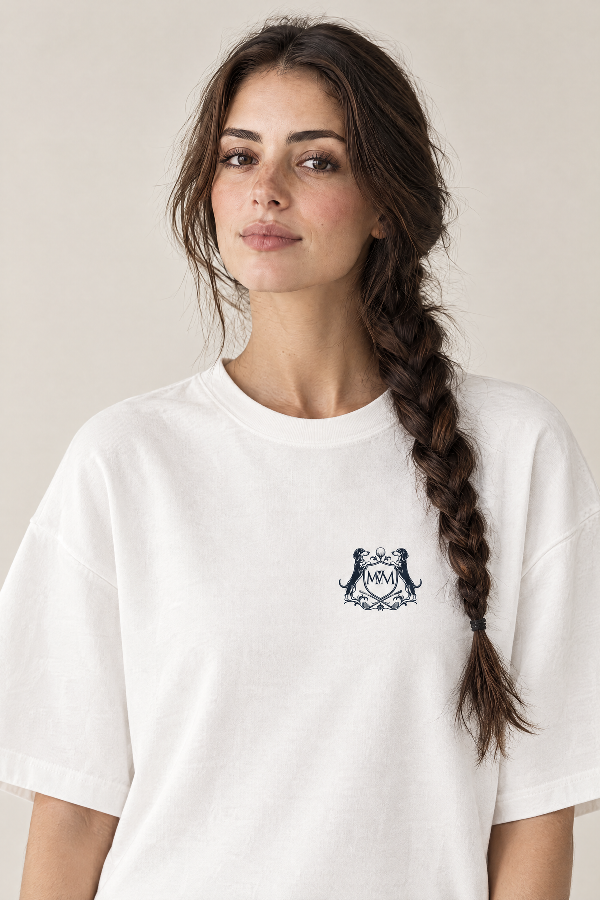 Woman wearing the white Club Crest tee, close-up of the small navy Golf & Dachshund Club crest at the left chest