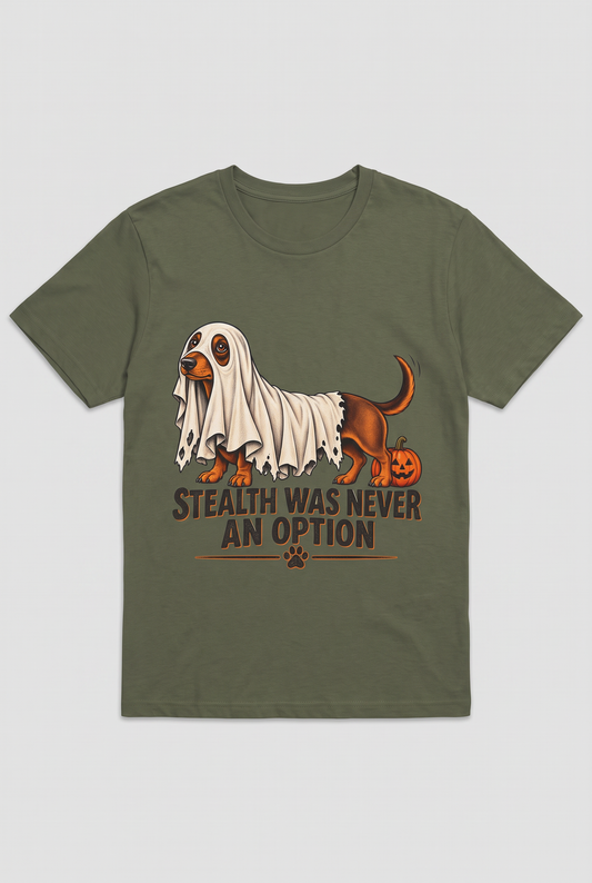 Flat lay of a military green dachshund Halloween t-shirt with a wiener dog under a too-short ghost sheet and the text Stealth Was Never An Option