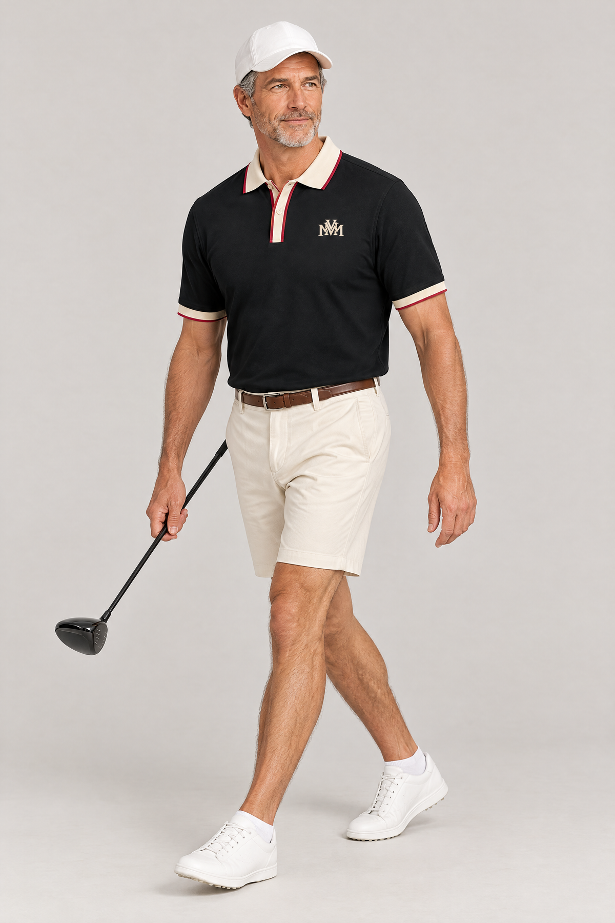 Man walking with a driver in the black Club Crest polo with apricot trim, cream golf shorts and a white cap. Color: Black with Apricot