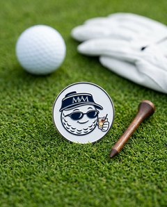 19th Hole golf ball marker in navy and cream print on grass with a wooden tee and golf glove
