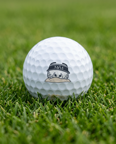 Bunker Buddy golf ball in navy and cream print, close-up on green grass