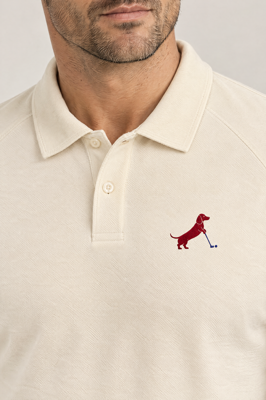 Close-up of collar and chest logo on apricot Putting dachshund golf polo. Color: Apricot