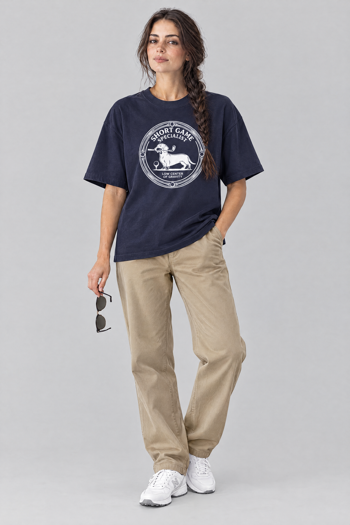 Woman wearing the Short Game Specialist Dachshund Golf Tee in navy with khaki trousers, holding sunglasses. Color: Navy