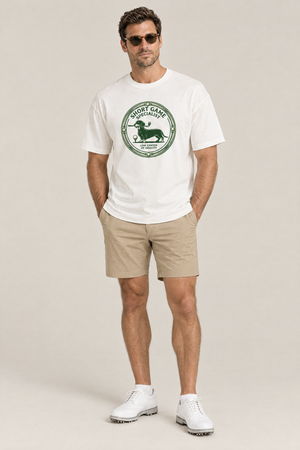 Man wearing the Short Game Specialist Dachshund Golf Tee in white with khaki golf shorts and sunglasses. Color: White