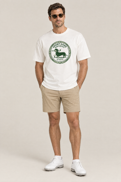 Man wearing the Short Game Specialist Dachshund Golf Tee in white with khaki golf shorts and sunglasses. Color: White