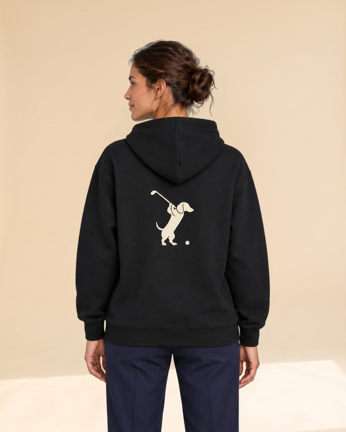 Woman wearing Club & Swing dachshund golf hoodie, back studio view. Color: Black
