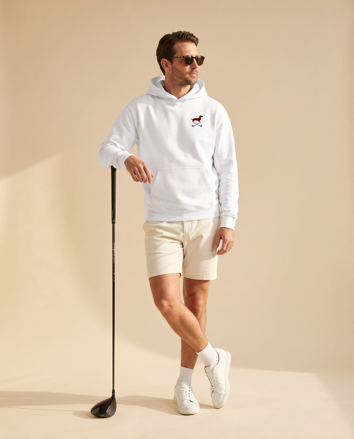 Man wearing Club & Swing dachshund golf hoodie, full-body studio look. Color: White