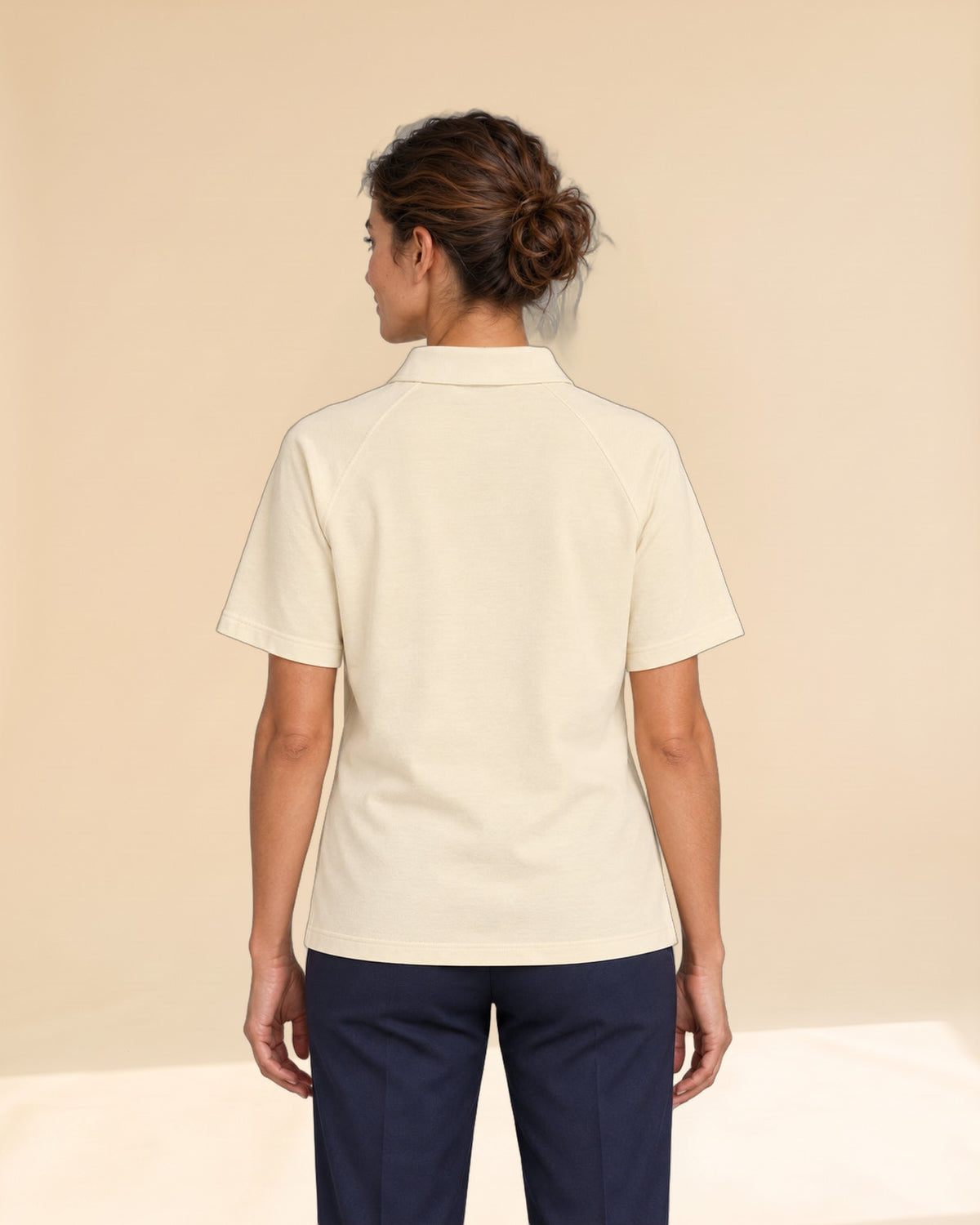 Woman wearing Putting dachshund golf polo, back studio view. Color: Apricot