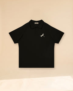 Putting dachshund golf polo, front flatlay. Color: Black