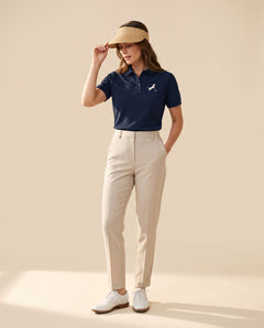 Woman wearing Putting dachshund golf polo, full-body studio look. Color: Navy Blue