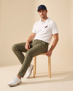Man wearing Putting dachshund golf polo, full-body studio look. Color: White