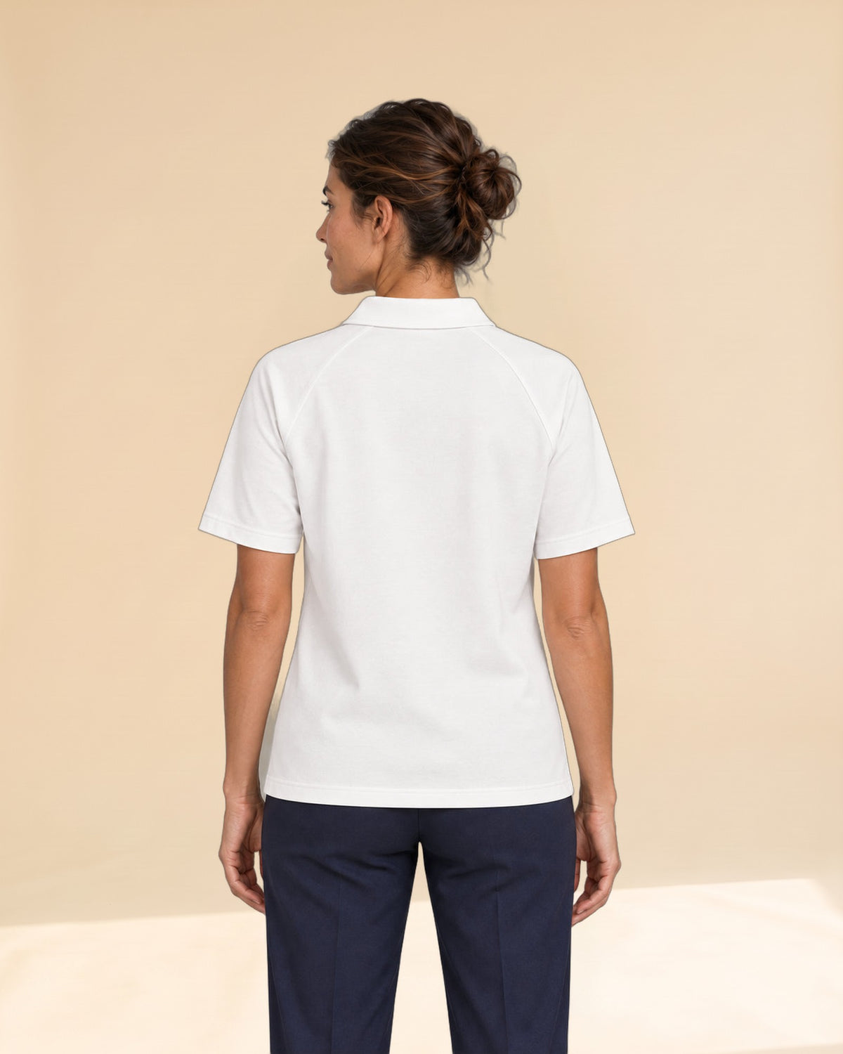 Woman wearing Putting dachshund golf polo, back studio view. Color: White