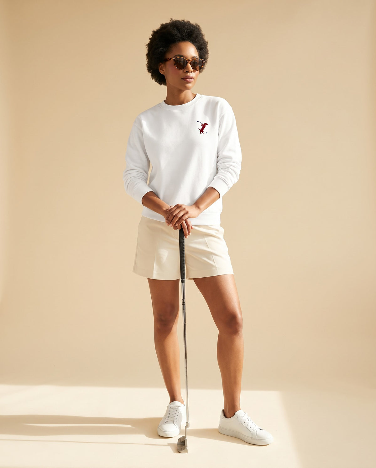 Woman wearing Swing dachshund golf sweatshirt, full-body studio look. Color: White