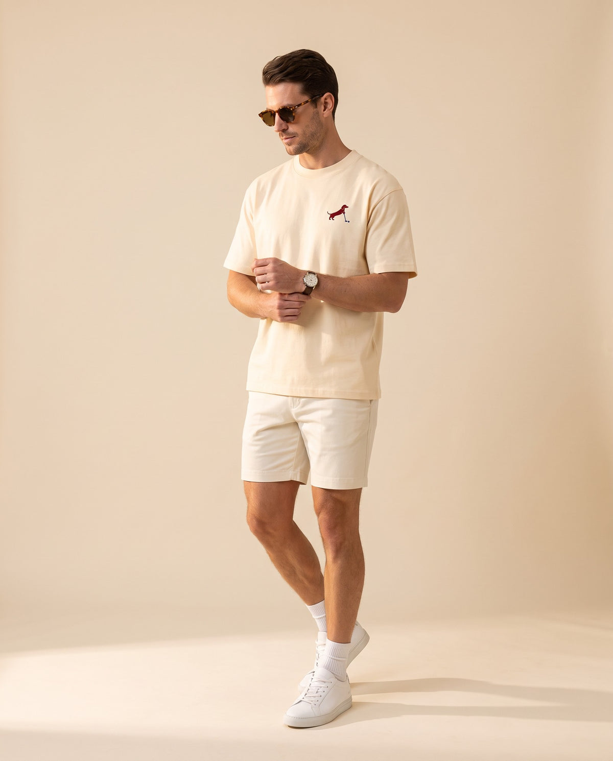 Man wearing Putting dachshund golf T-shirt, full-body studio look. Color: Apricot