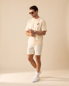 Man wearing Putting dachshund golf T-shirt, full-body studio look. Color: Apricot