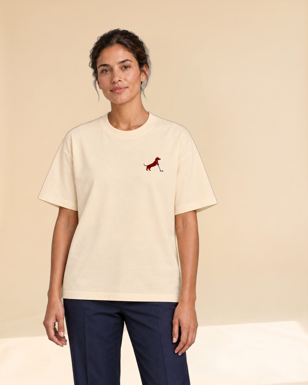 Woman wearing Putting dachshund golf T-shirt, front studio view. Color: Apricot