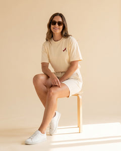 Woman wearing Putting dachshund golf T-shirt, full-body studio look. Color: Apricot