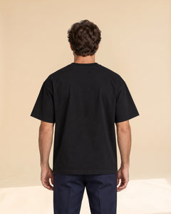 Man wearing Putting dachshund golf T-shirt, back studio view. Color: Black