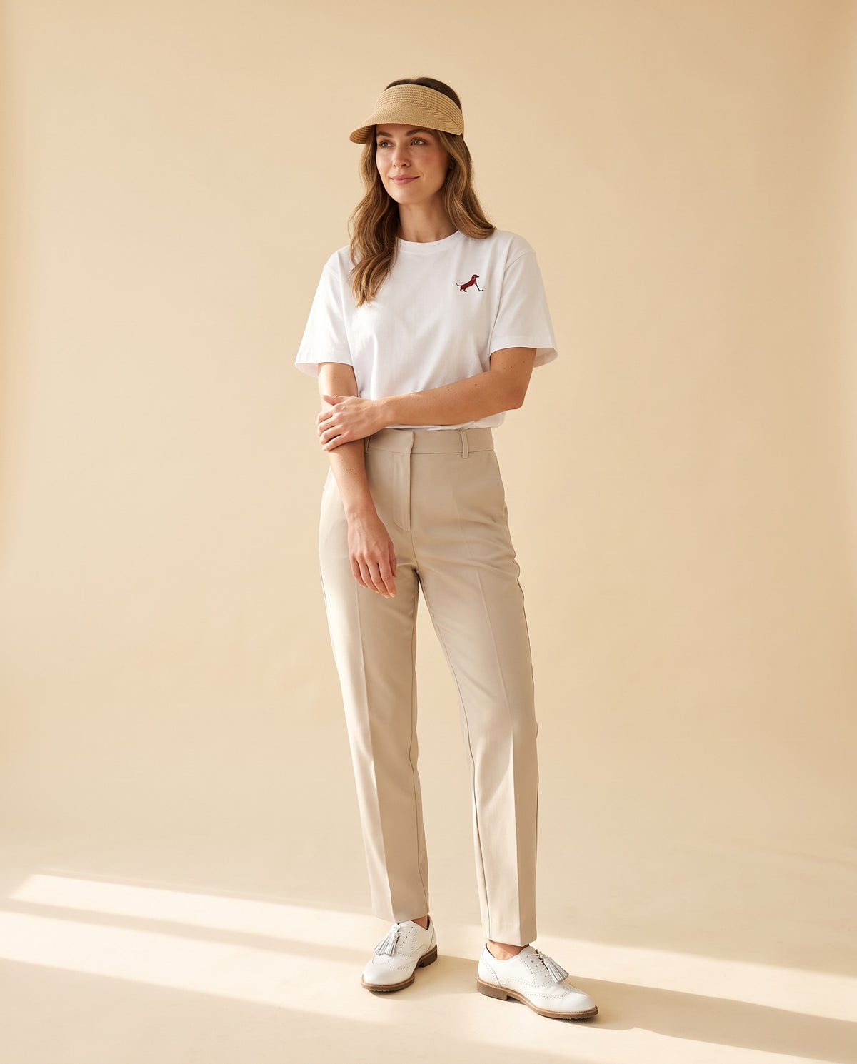 Woman wearing Putting dachshund golf T-shirt, full-body studio look. Color: White