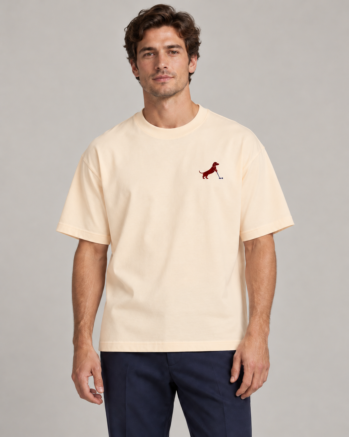 Man wearing Putting dachshund golf T-shirt, front studio view. Color: Apricot