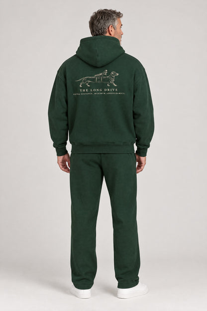Man seen from behind in The Long Drive dachshund golf hoodie in Blackish Green, showing the large back print. Color: Blackish Green