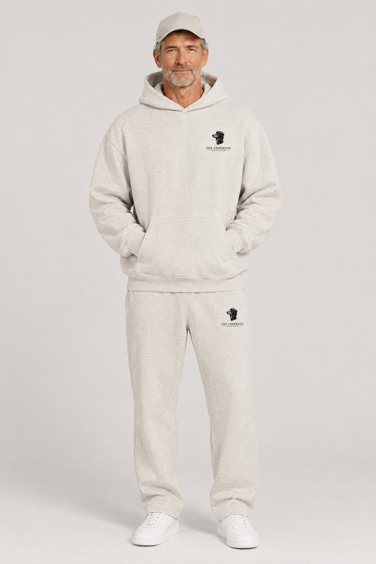 Man wearing The Long Drive dachshund golf hoodie and matching Underdog Golf Club sweatpants in Oat Gray, front view. Color: Oat Gray