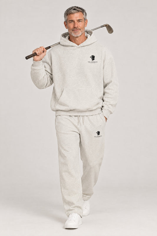 Man walking in The Long Drive dachshund golf hoodie and sweatpants set in Oat Gray. Color: Oat Gray