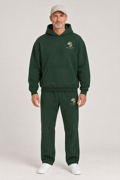 Man wearing The Sweet Spot Dalmatian golf hoodie and matching Underdog Golf Club sweatpants in Blackish Green, front view. Color: Blackish Green