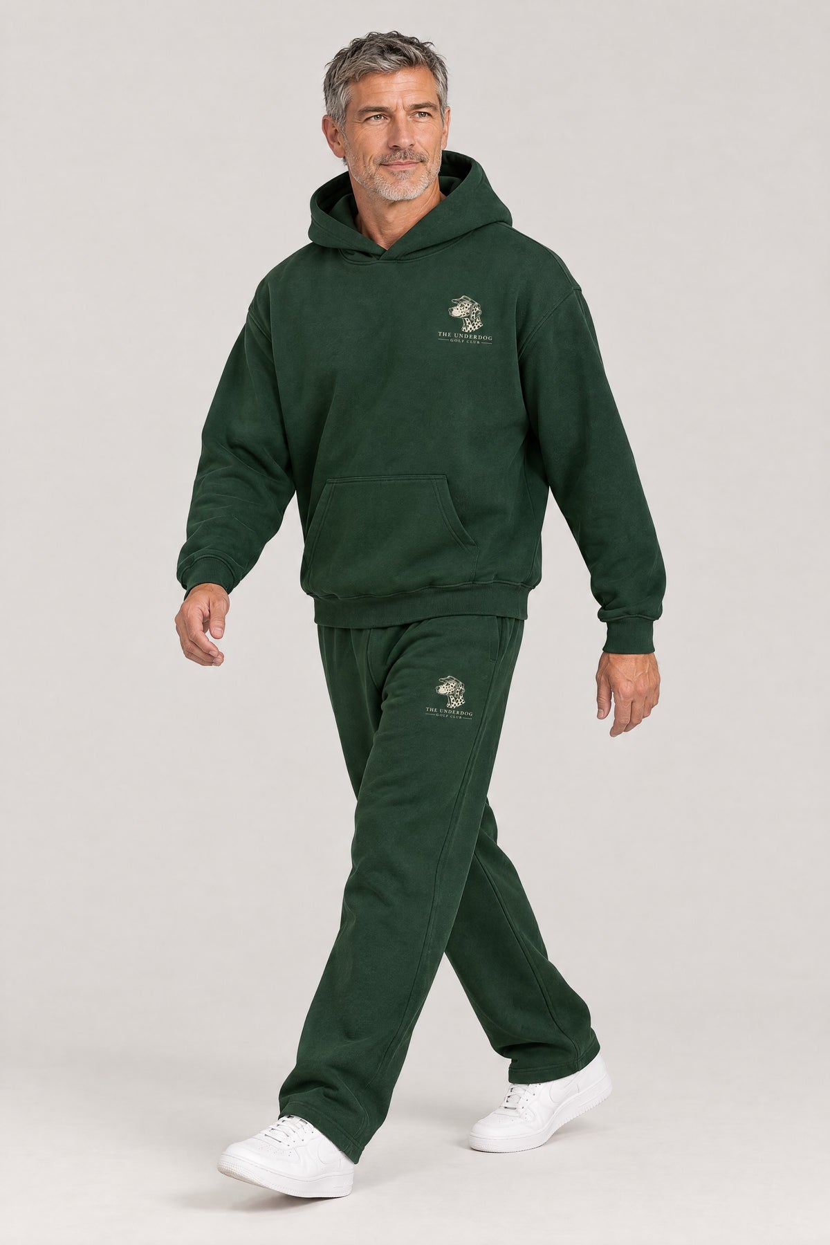 Man walking in The Sweet Spot Dalmatian golf hoodie and sweatpants set in Blackish Green. Color: Blackish Green