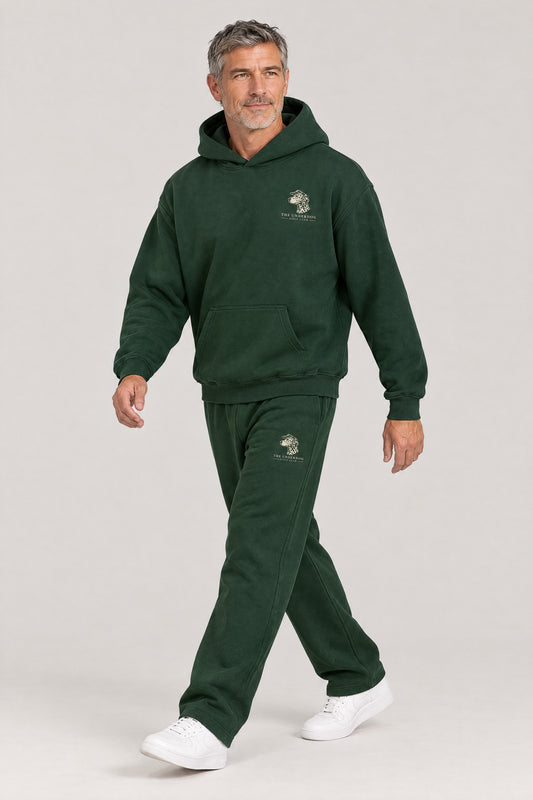 Man walking in The Sweet Spot Dalmatian golf hoodie and sweatpants set in Blackish Green. Color: Blackish Green