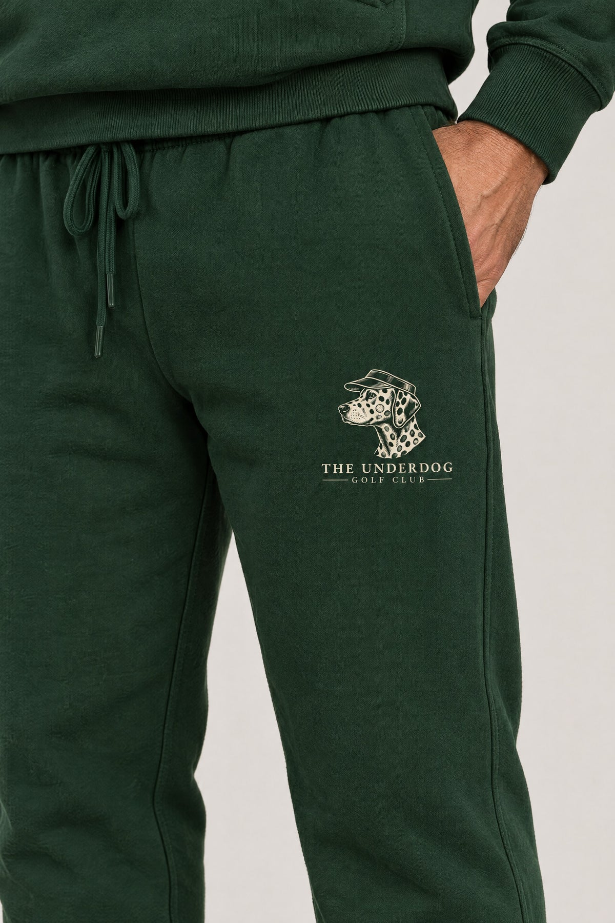 Close-up of The Underdog Golf Club Dalmatian crest on the left thigh of the Blackish Green sweatpants. Color: Blackish Green