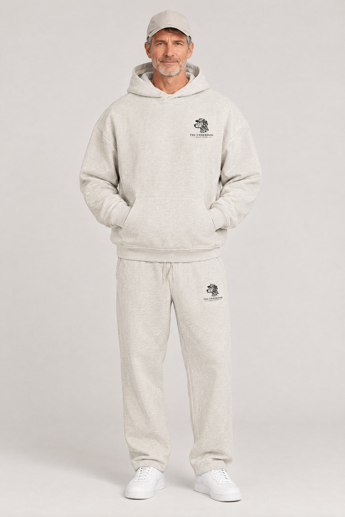 Man wearing The Sweet Spot Dalmatian golf hoodie and matching Underdog Golf Club sweatpants in Oat Gray, front view. Color: Oat Gray