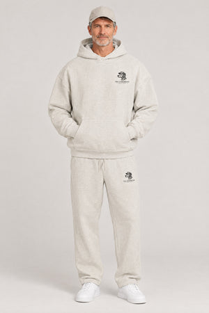 Man wearing The Sweet Spot Dalmatian golf hoodie and matching Underdog Golf Club sweatpants in Oat Gray, front view. Color: Oat Gray