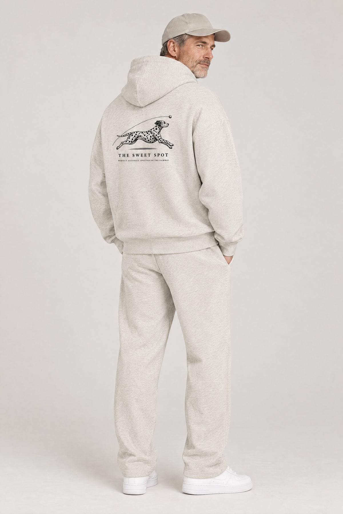 Man seen from behind in The Sweet Spot Dalmatian golf hoodie in Oat Gray, showing the large back print. Color: Oat Gray