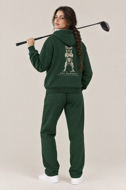 Woman with a driver over her shoulder, back view of The Marshal French Bulldog golf hoodie in Blackish Green with the large back print. Color: Blackish Green