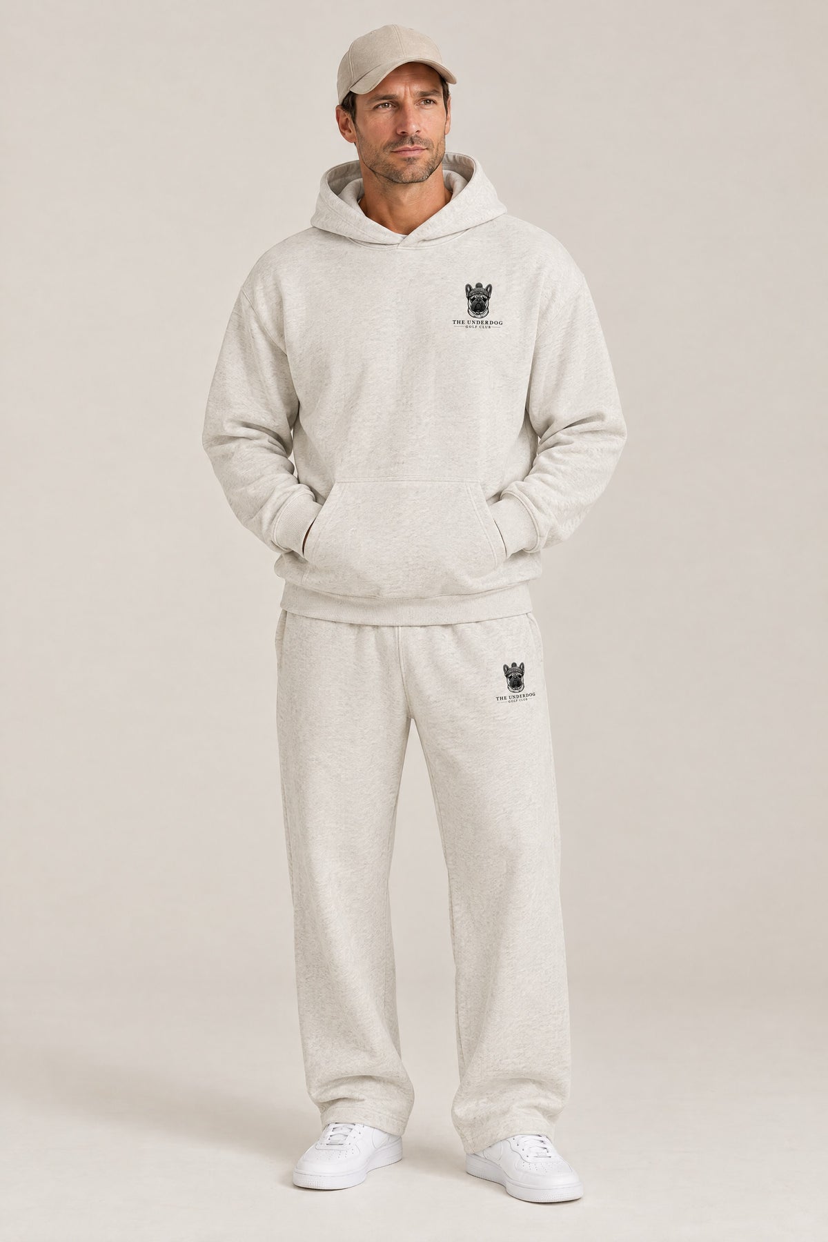Man wearing The Marshal French Bulldog golf hoodie and matching Underdog Golf Club sweatpants in Oat Gray, front view. Color: Oat Gray