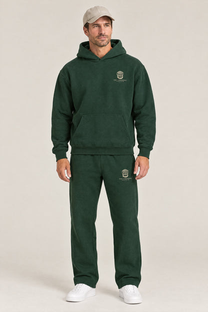 Man wearing The Heavy Hitter pug golf hoodie and matching Underdog Golf Club sweatpants in Blackish Green, front view. Color: Blackish Green