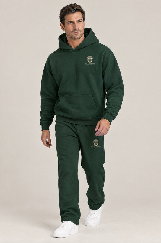 Man walking in The Heavy Hitter pug golf hoodie and sweatpants set in Blackish Green. Color: Blackish Green